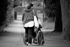 женщина катит инвалидную коляску