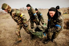 Украинские солдаты несут раненного