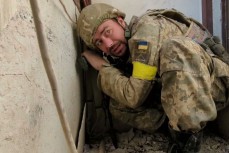 Украинский солдат прячется от обстрела