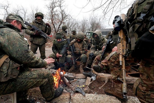 Российские солдаты греются у костра на привале