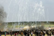 30 марта 2018 года палестинские демонстранты бегут от слезоточивого газа, выпущенного израильскими военными вблизи границы с Израилем, к востоку от Газы