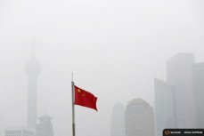 Флаг Китая на фоне городского смога.