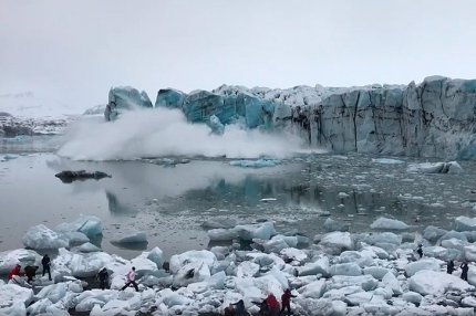 Кусок ледника откалывается и падает в воду
