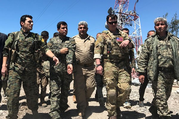 Военный командир США идет с курдскими бойцами из Народных защитных подразделений (YPG) в штаб-квартиру YPG, которая была атакована турецкими авиаударами на горе Карачок возле Маликии.