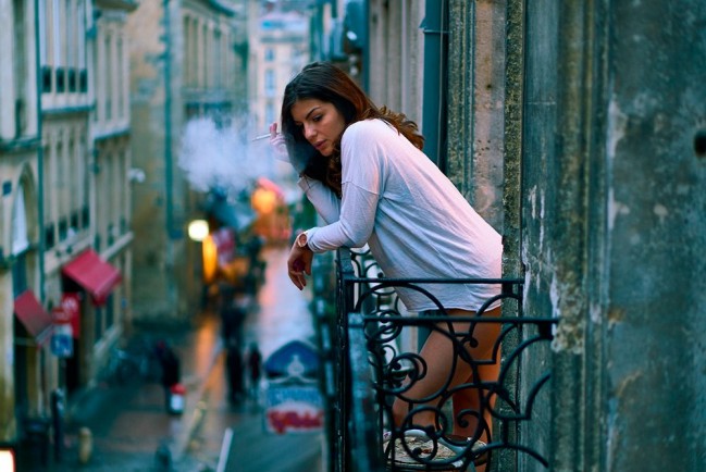 Девушка курит на балконе