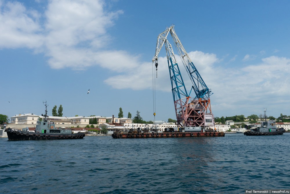 Бурсиры тянут плавучий кран в севастопольской бухте